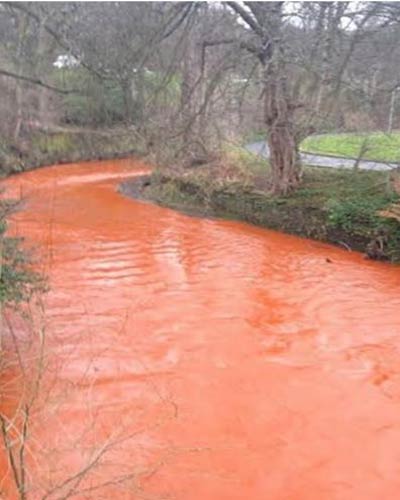 نهر يتحول لونه إلى البرتقالي بفعل الفيضانات في بريطانيا (بالصور)
